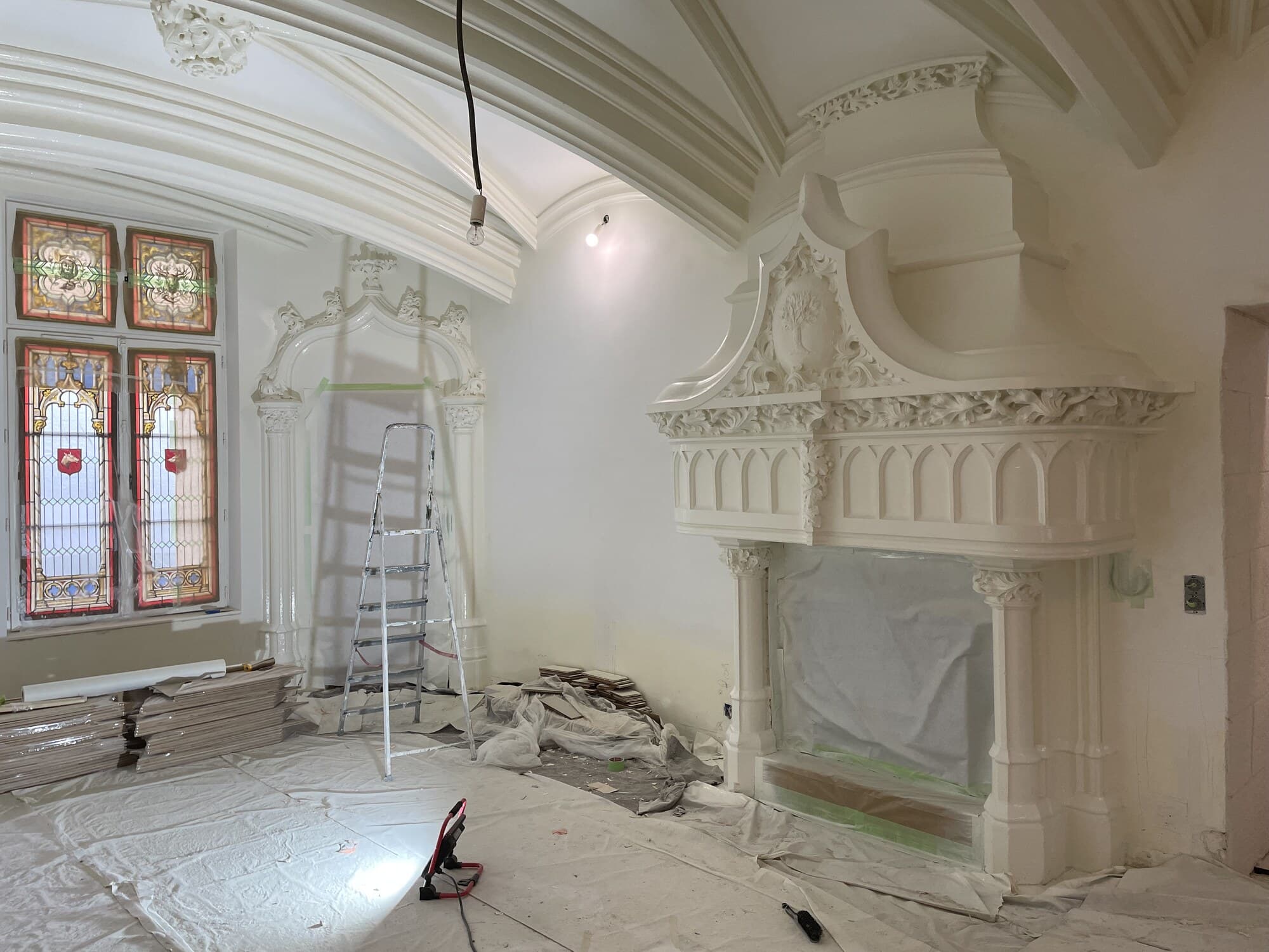 Château en chantier avec voûtes, vitraux gothiques et cheminée sculptée