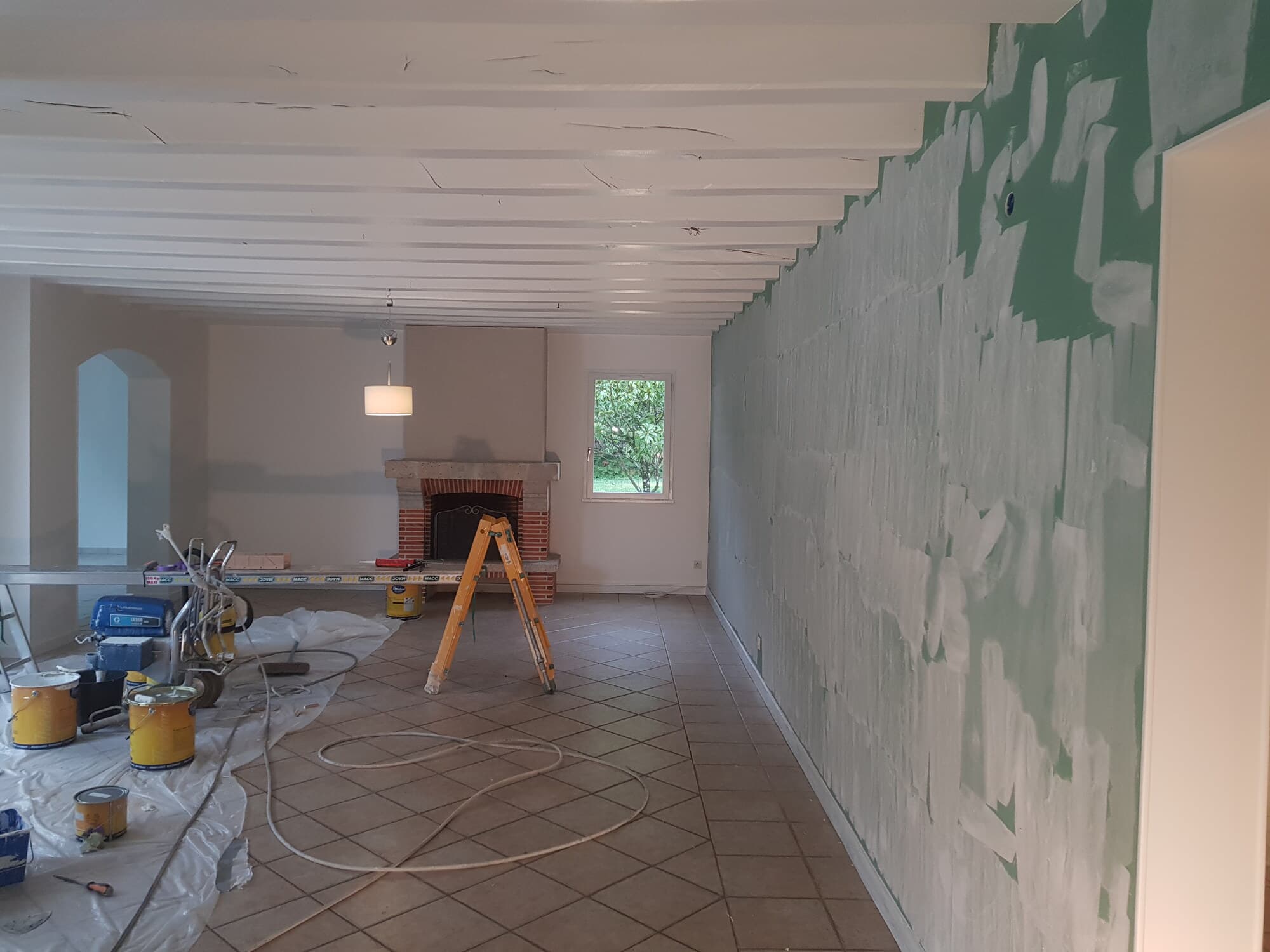 Salon avec cheminée brique, mur vert avant peinture