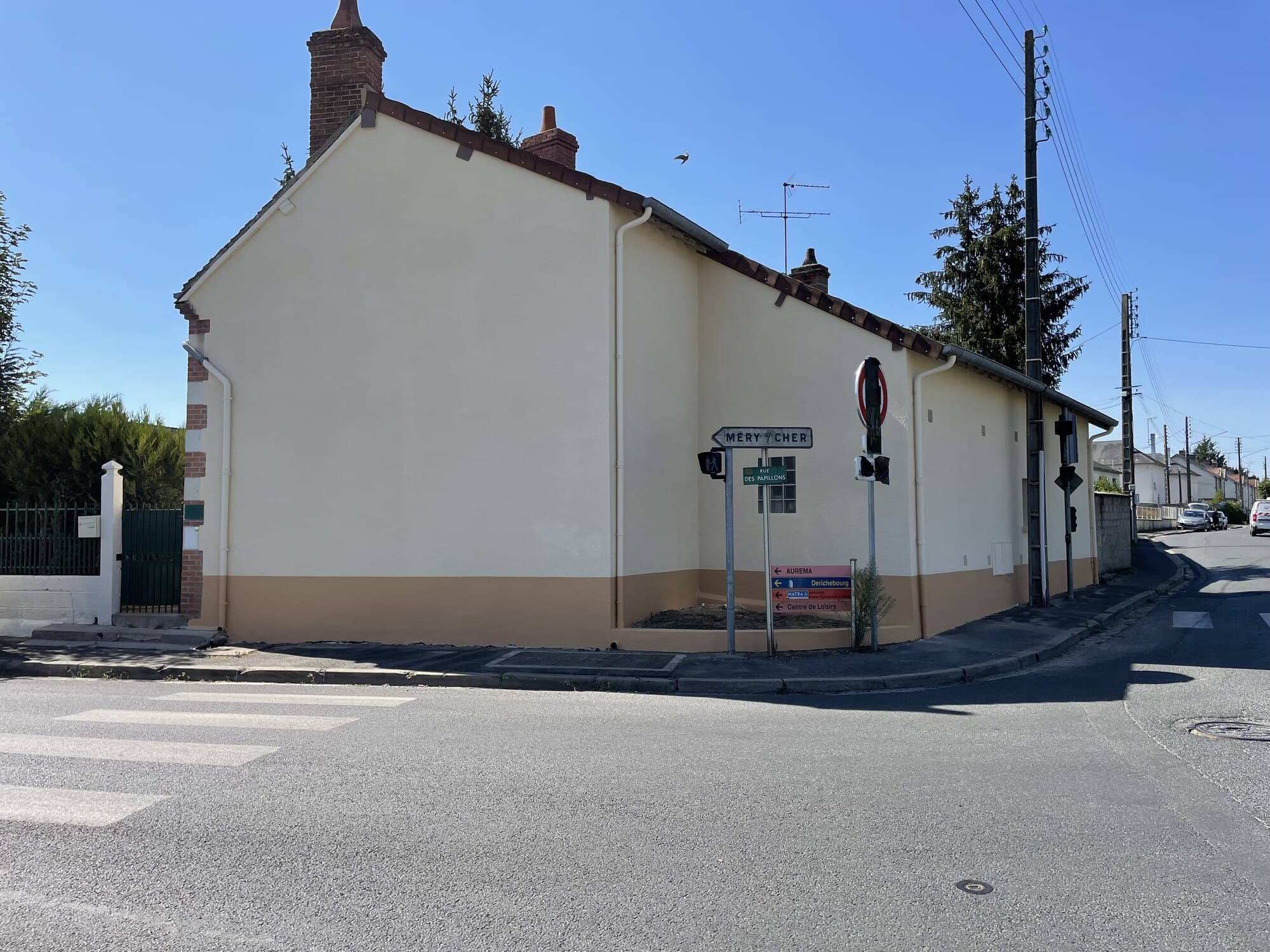 Maison d'angle peinte en crème avec soubassement beige