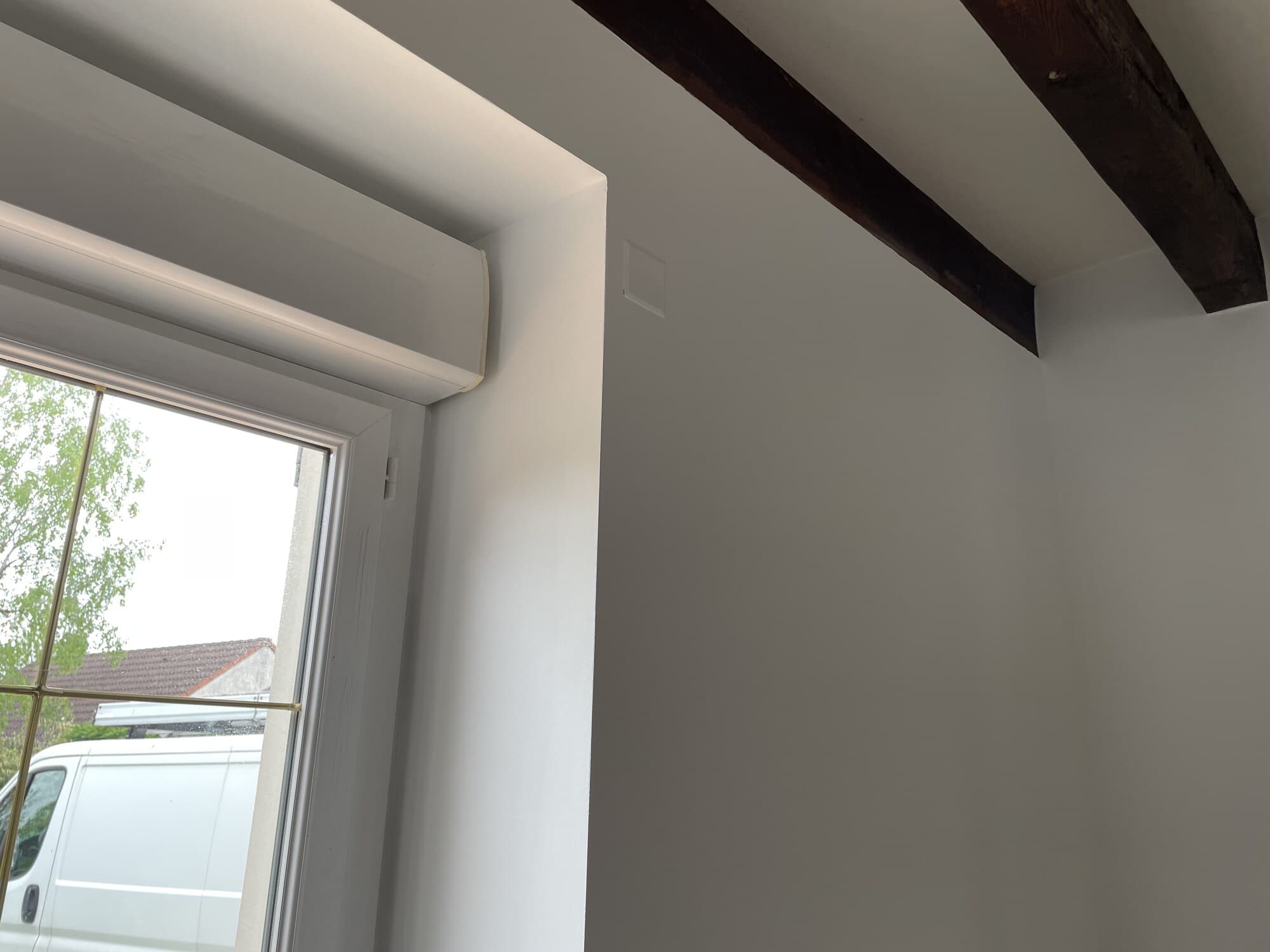 Détail d'angle avec fenêtre et poutre apparente après peinture