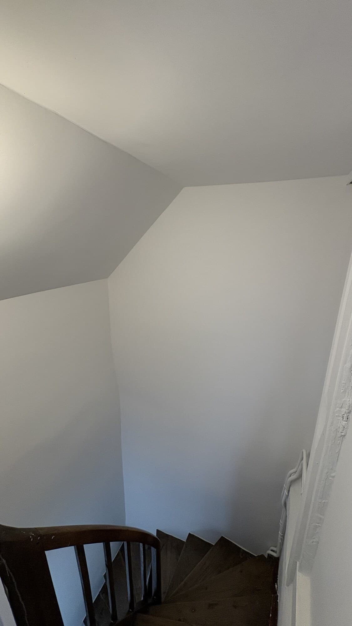 Cage d'escalier blanche menant aux combles