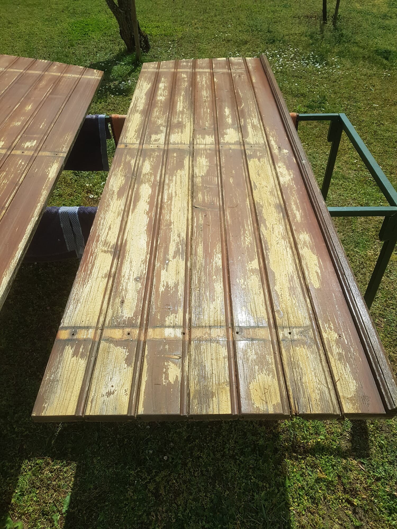 Vantaux de portail en bois posés sur l'herbe avec peinture délavée