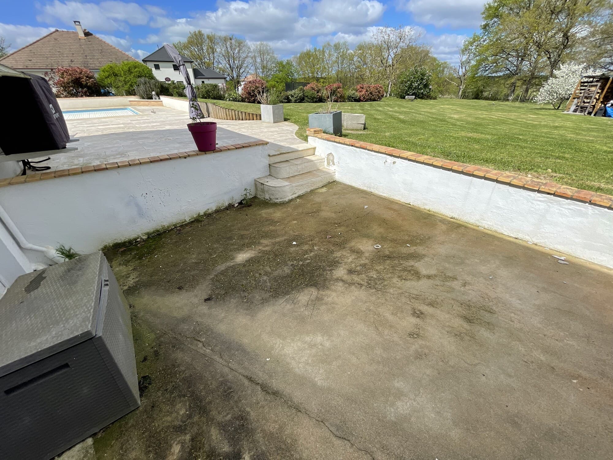 Terrasse béton à nettoyer avec piscine en arrière-plan