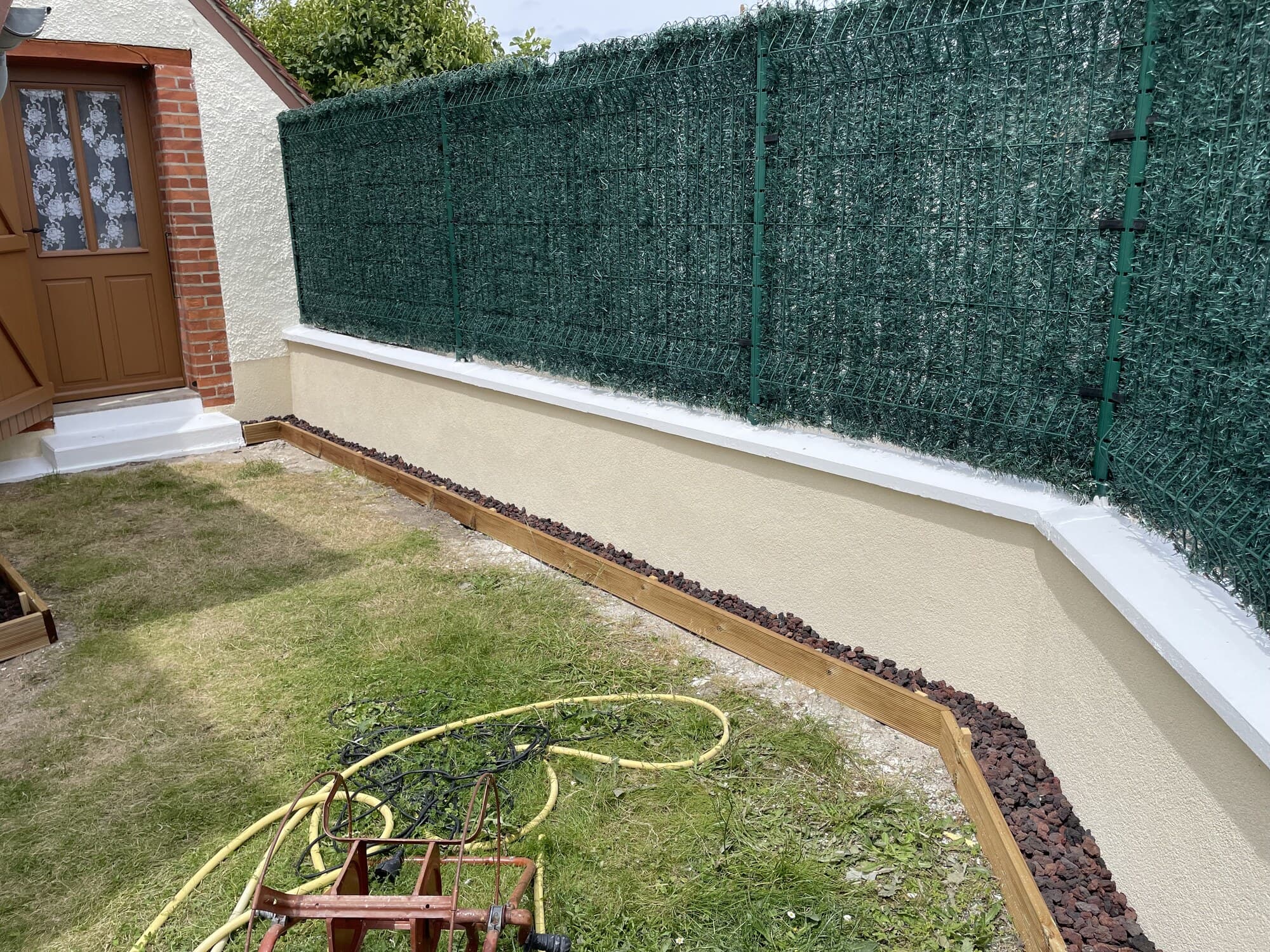 Muret extérieur fini avec lit de galets décoratifs