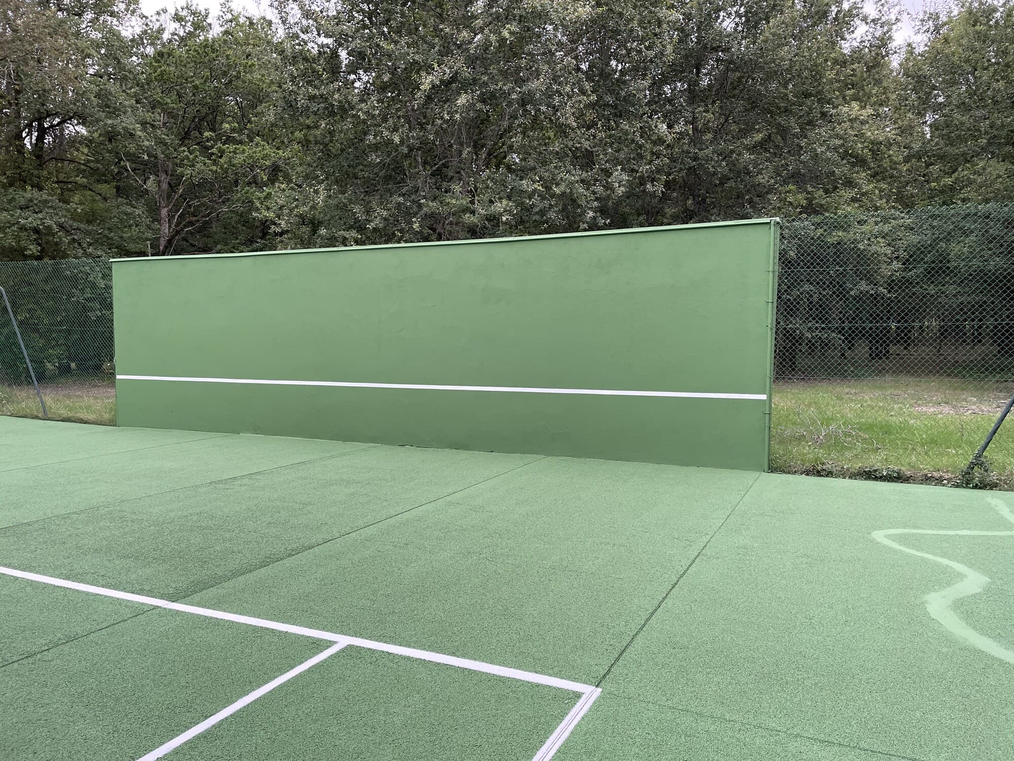 Mur d'entraînement de tennis peint en vert