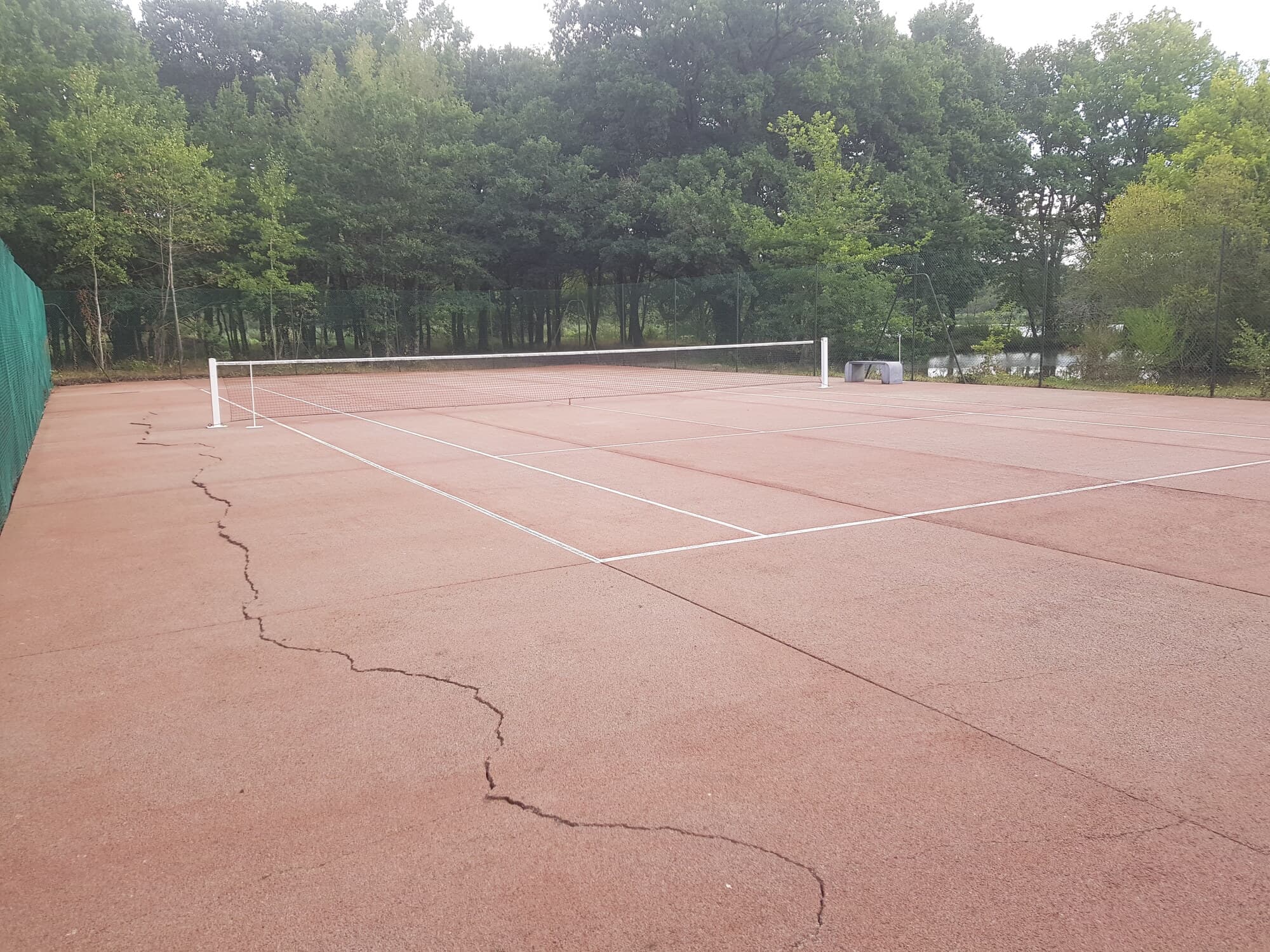 Détail d'un terrain de tennis rouge fissuré